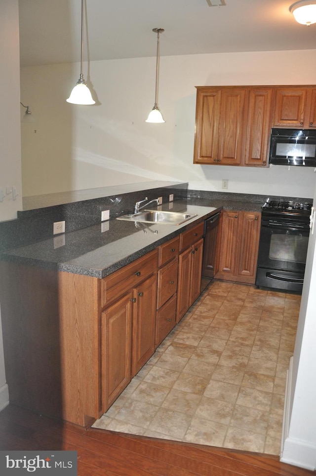 kitchen featuring kitchen peninsula, sink, black appliances, and decorative light fixtures