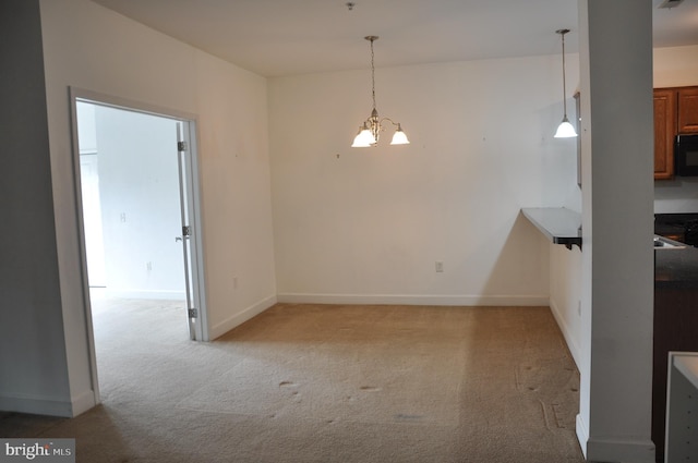 unfurnished dining area with a chandelier and light carpet