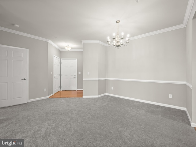 carpeted empty room featuring ornamental molding and a notable chandelier