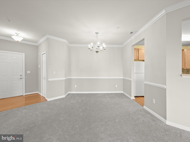 carpeted empty room with crown molding and a chandelier