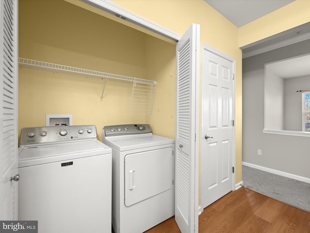 clothes washing area featuring washer and dryer and hardwood / wood-style flooring