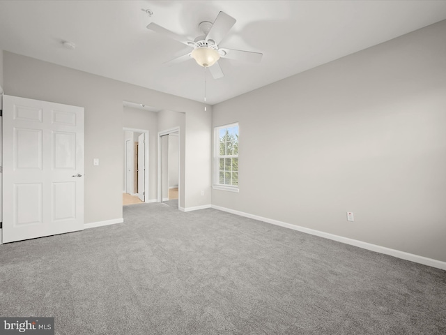 unfurnished bedroom featuring carpet flooring, ensuite bath, and ceiling fan