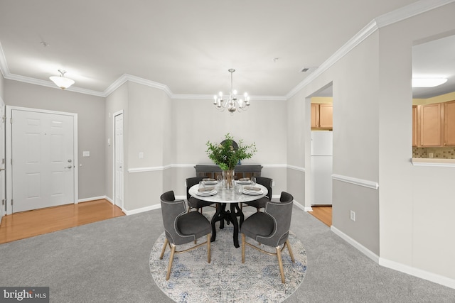 carpeted dining area with crown molding and an inviting chandelier