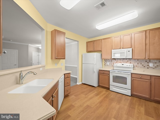 kitchen with sink, light hardwood / wood-style flooring, backsplash, white appliances, and ornamental molding