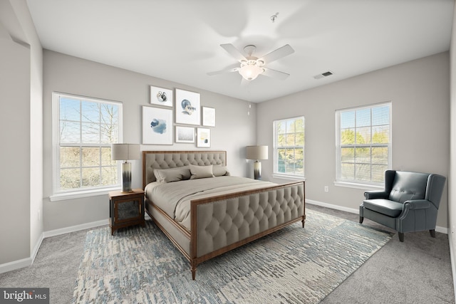 carpeted bedroom with multiple windows and ceiling fan