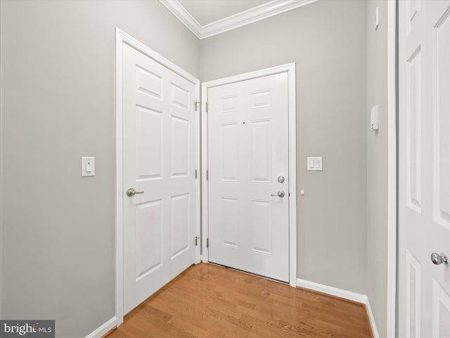 doorway with crown molding and light hardwood / wood-style flooring