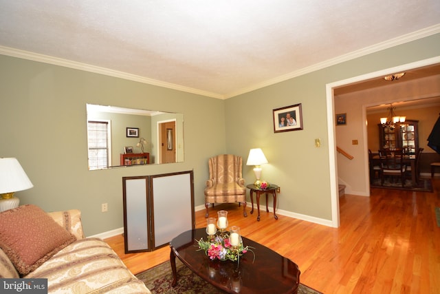 living room with light hardwood / wood-style floors, crown molding, and an inviting chandelier