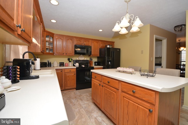 kitchen with a center island, an inviting chandelier, black appliances, a breakfast bar, and decorative light fixtures