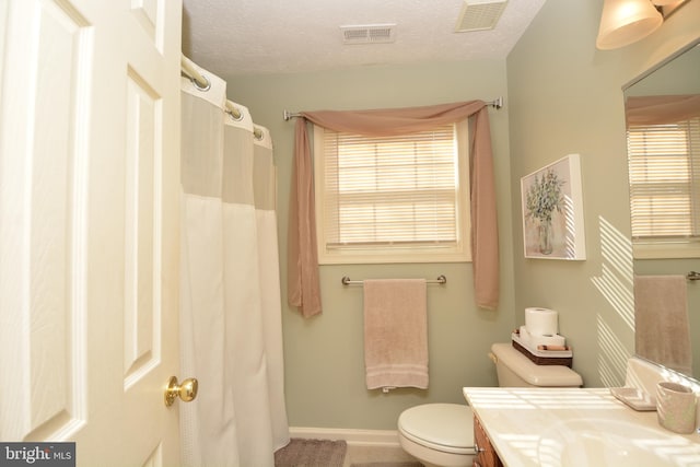 bathroom with toilet, vanity, and a textured ceiling