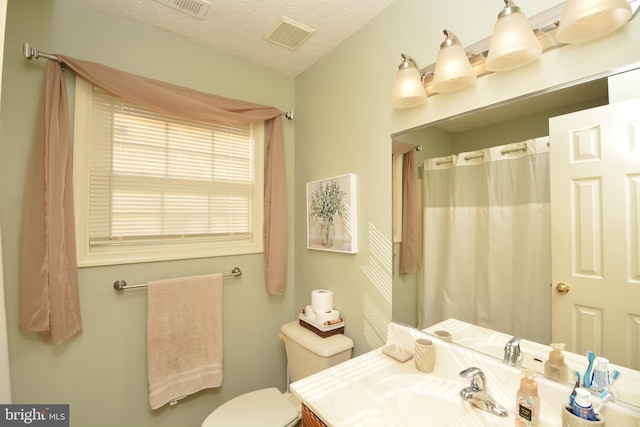 bathroom featuring toilet, vanity, and a textured ceiling