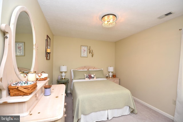 bedroom with a textured ceiling and light carpet