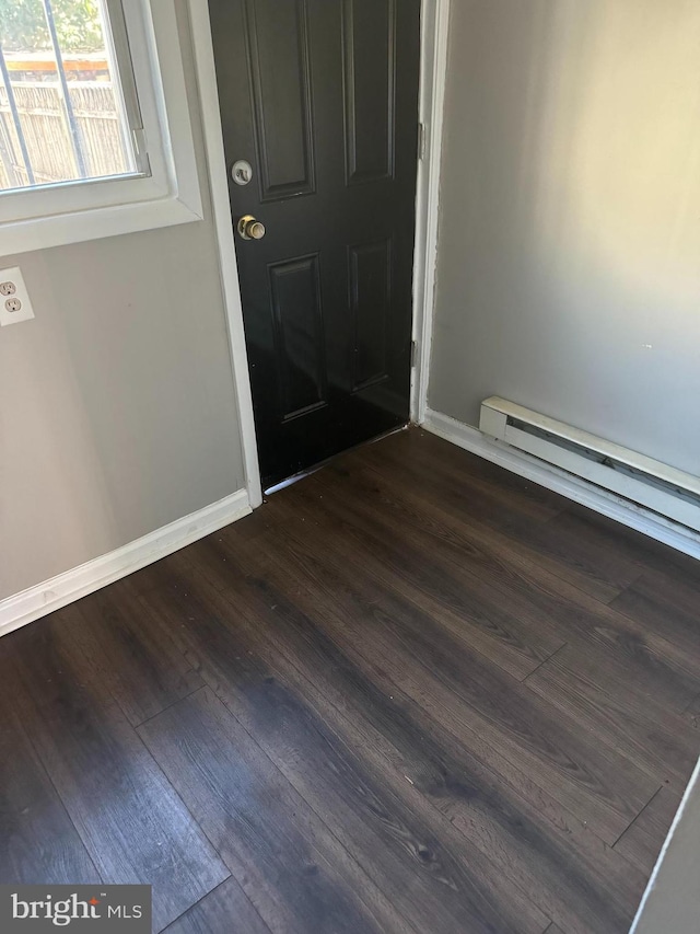 entrance foyer with a baseboard radiator and dark hardwood / wood-style flooring