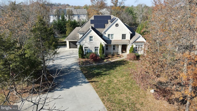 view of front property featuring a front yard and solar panels