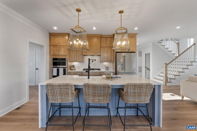 kitchen featuring a kitchen breakfast bar, hardwood / wood-style flooring, a large island, and appliances with stainless steel finishes