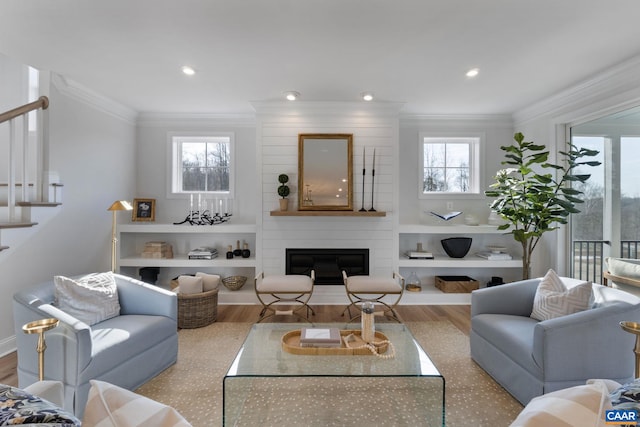 living room with a fireplace, a healthy amount of sunlight, and light hardwood / wood-style flooring