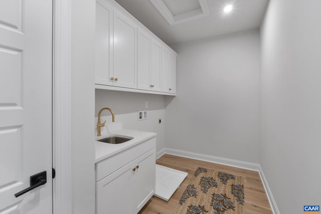 laundry room with cabinets, light hardwood / wood-style floors, sink, hookup for an electric dryer, and hookup for a washing machine