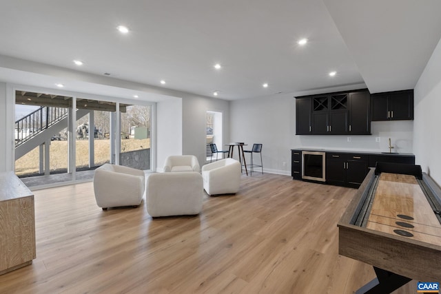 living room with indoor wet bar and light hardwood / wood-style flooring