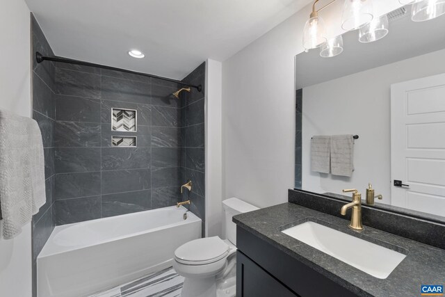 full bathroom with toilet, vanity, and tiled shower / bath