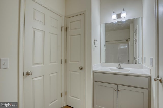 bathroom featuring a shower and vanity