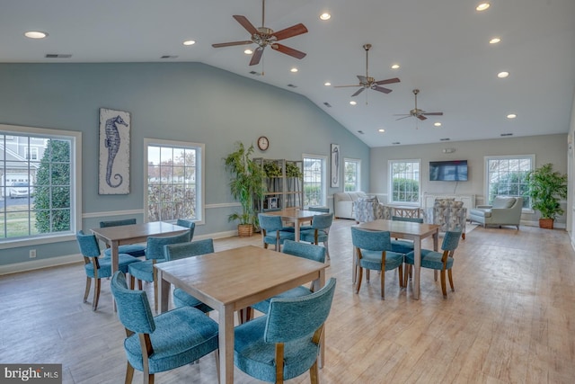 dining space featuring high vaulted ceiling, light hardwood / wood-style flooring, and ceiling fan