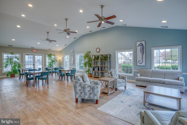 living room featuring high vaulted ceiling, light hardwood / wood-style floors, and ceiling fan