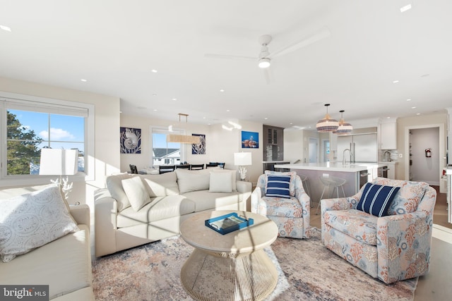 living room with light hardwood / wood-style flooring and ceiling fan