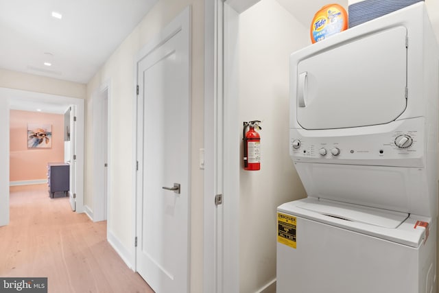 laundry area featuring light hardwood / wood-style flooring and stacked washer / drying machine