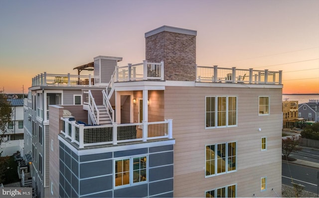 back house at dusk with a balcony