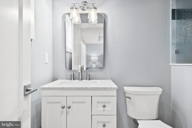 bathroom featuring vanity and toilet