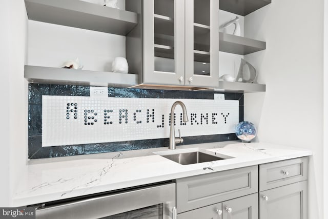 interior space with wine cooler, backsplash, light stone counters, and sink