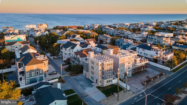 aerial view at dusk featuring a water view