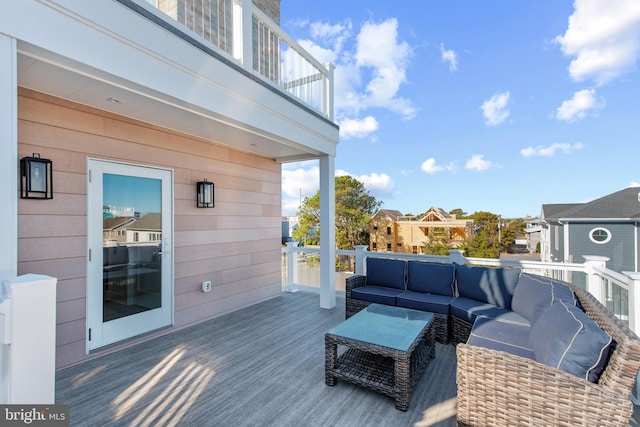 wooden terrace with an outdoor living space