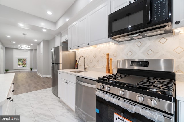 kitchen featuring light hardwood / wood-style floors, sink, appliances with stainless steel finishes, white cabinets, and decorative backsplash