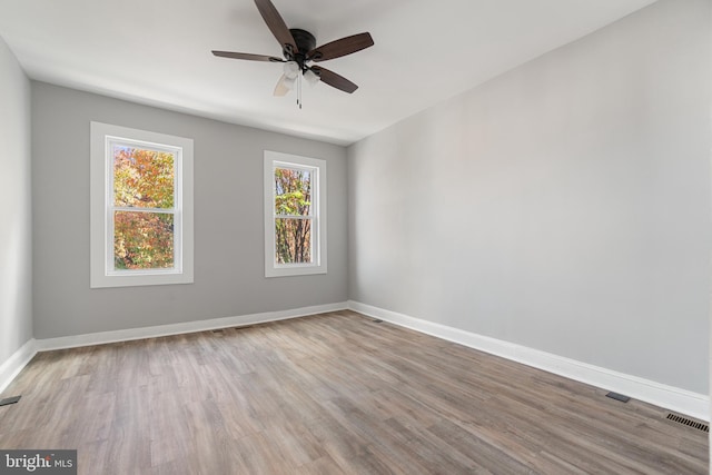 empty room with ceiling fan and light hardwood / wood-style flooring