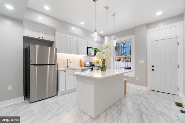 kitchen featuring a center island, white cabinets, sink, tasteful backsplash, and appliances with stainless steel finishes