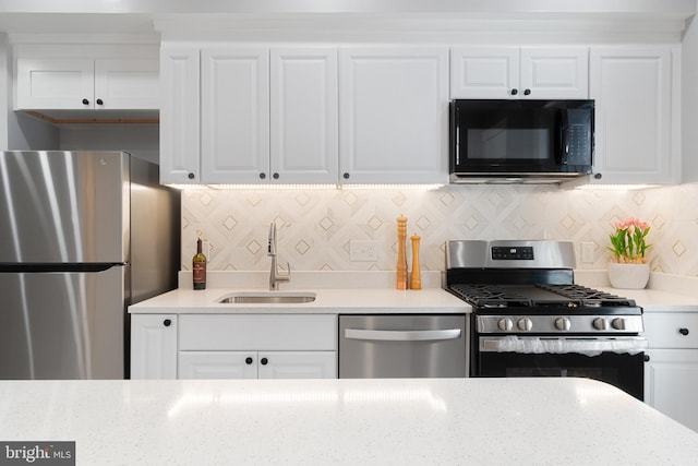 kitchen with white cabinetry, appliances with stainless steel finishes, and sink