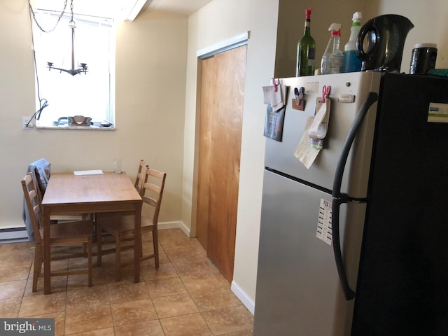 tiled dining room with a baseboard heating unit