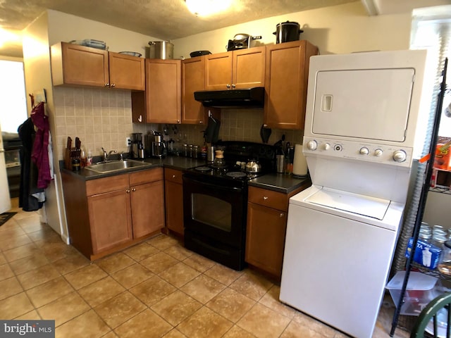 kitchen with electric range, sink, tasteful backsplash, light tile patterned floors, and stacked washer and clothes dryer