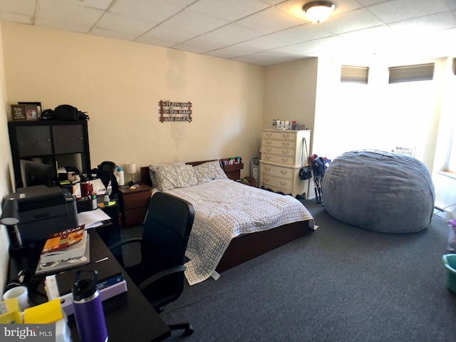 bedroom featuring carpet flooring and a drop ceiling