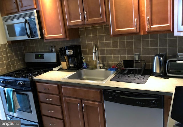 kitchen featuring appliances with stainless steel finishes, backsplash, and sink