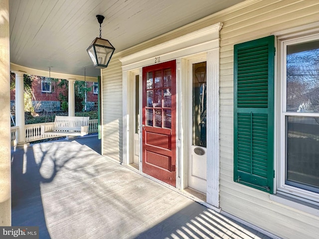 view of exterior entry featuring covered porch