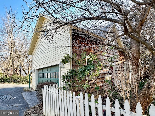 view of home's exterior featuring a fenced front yard and a garage