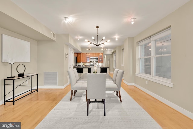 dining room featuring light wood-type flooring and a chandelier