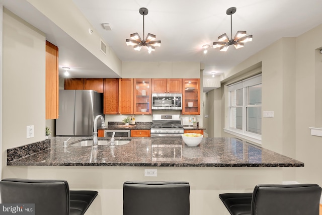 kitchen with kitchen peninsula, sink, a kitchen bar, and stainless steel appliances