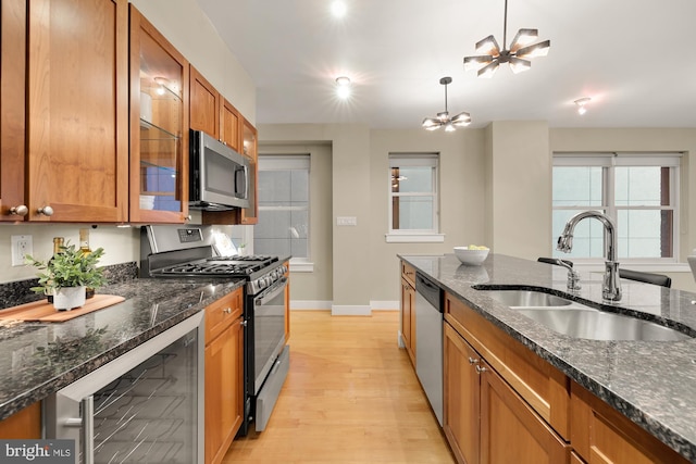 kitchen featuring stainless steel appliances, a notable chandelier, sink, light hardwood / wood-style flooring, and wine cooler