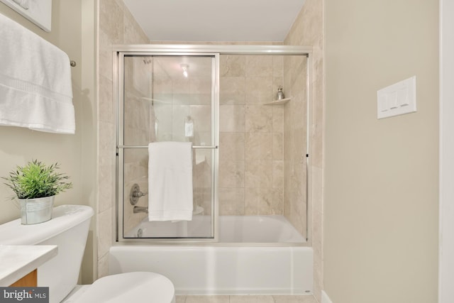 full bathroom featuring tile patterned flooring, enclosed tub / shower combo, toilet, and vanity