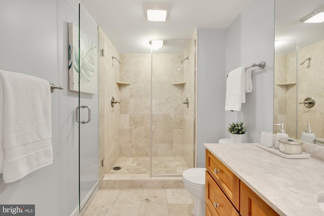 bathroom with a shower with door, vanity, toilet, and tile patterned flooring