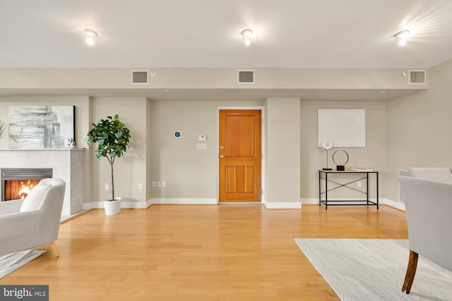 interior space featuring a tiled fireplace and hardwood / wood-style flooring