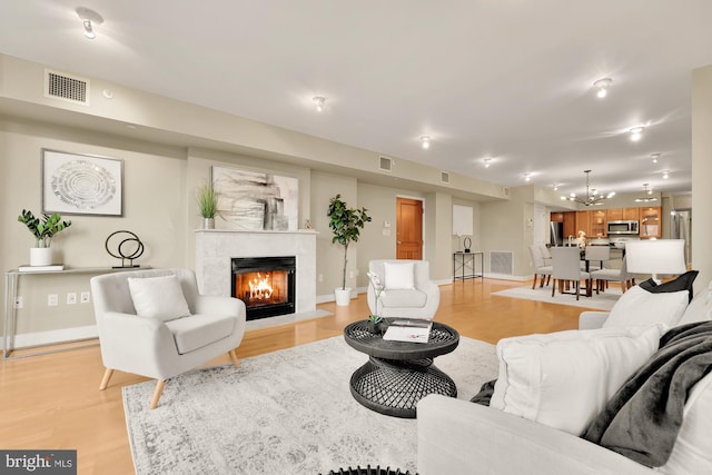 living room with a chandelier and light wood-type flooring