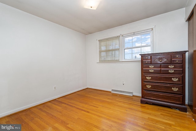 unfurnished bedroom with baseboard heating and light hardwood / wood-style flooring